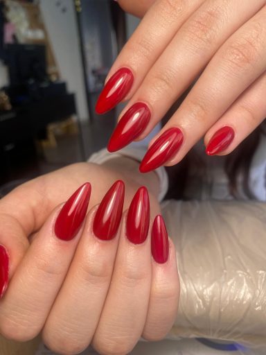 Uñas largas y afiladas pintadas de un intenso color rojo brillante.