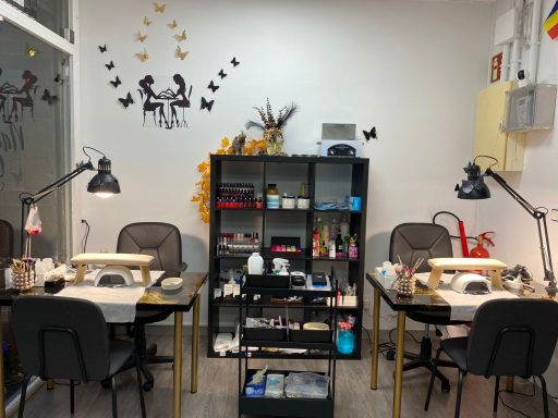 Espacio de trabajo con mesas, sillas y equipo para manicura. Decoración en las paredes.